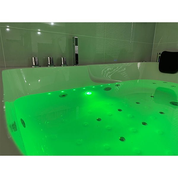 Green lit bathtub in a bathroom setting of Cascada Amalfi white acrylic two-person freestanding jacuzzi bathtub