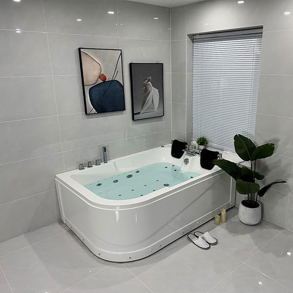 Modern bathroom with a Jacuzzi bathtub, gray tiles, and abstract art on the wall.