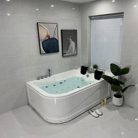 Modern bathroom with a Jacuzzi bathtub, gray tiles, and abstract art on the wall.
