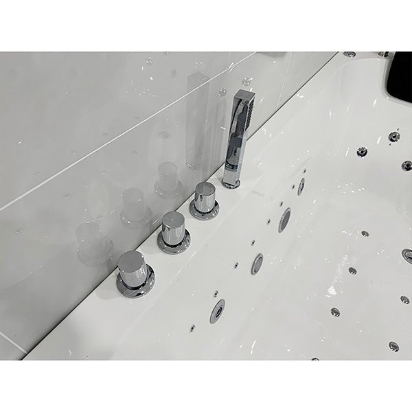 Close-up of a bathtub with faucet and control knobs of Cascada Amalfi white acrylic two-person freestanding jacuzzi bathtub